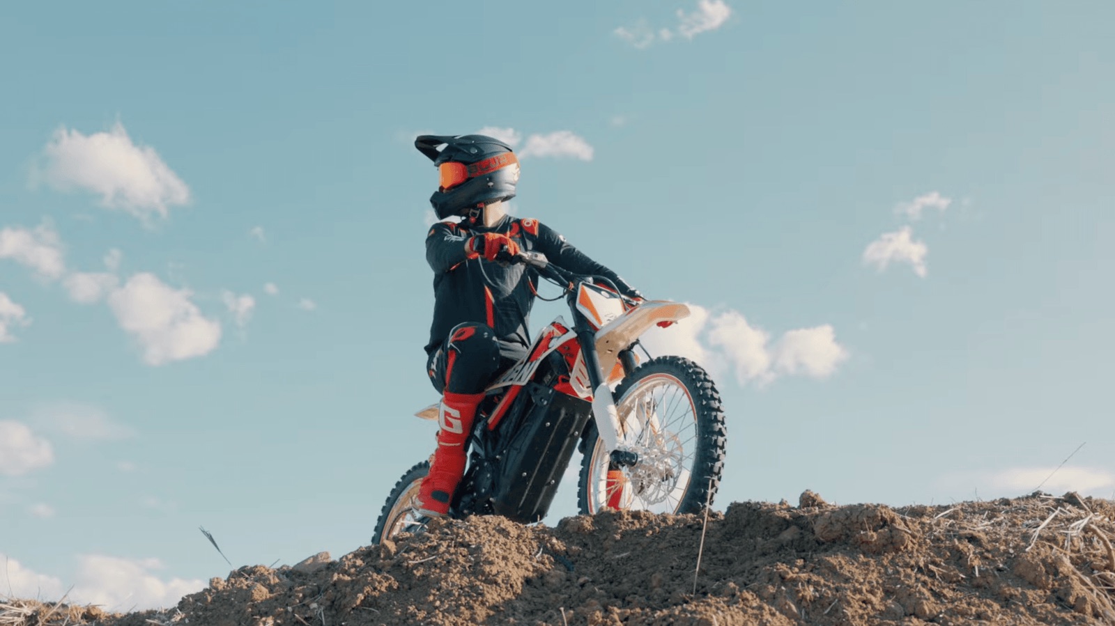 Rider on an RFN electric dirt bike at the top of a dirt mound